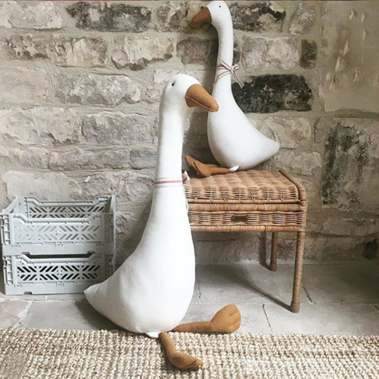 Plüschtier und Kissen in Gans-Form