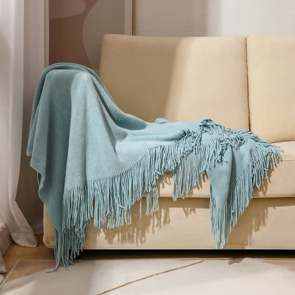 Grob gestrickte Decke mit Quasten