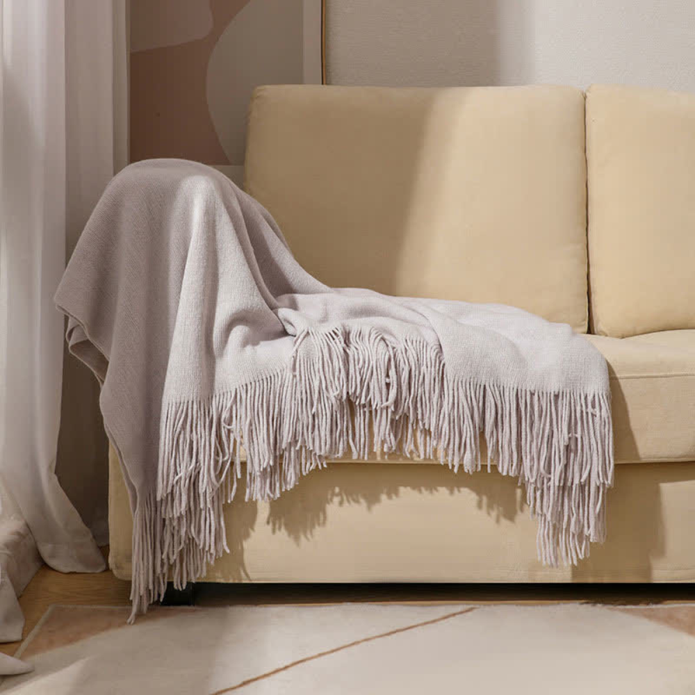 Grob gestrickte Decke mit Quasten